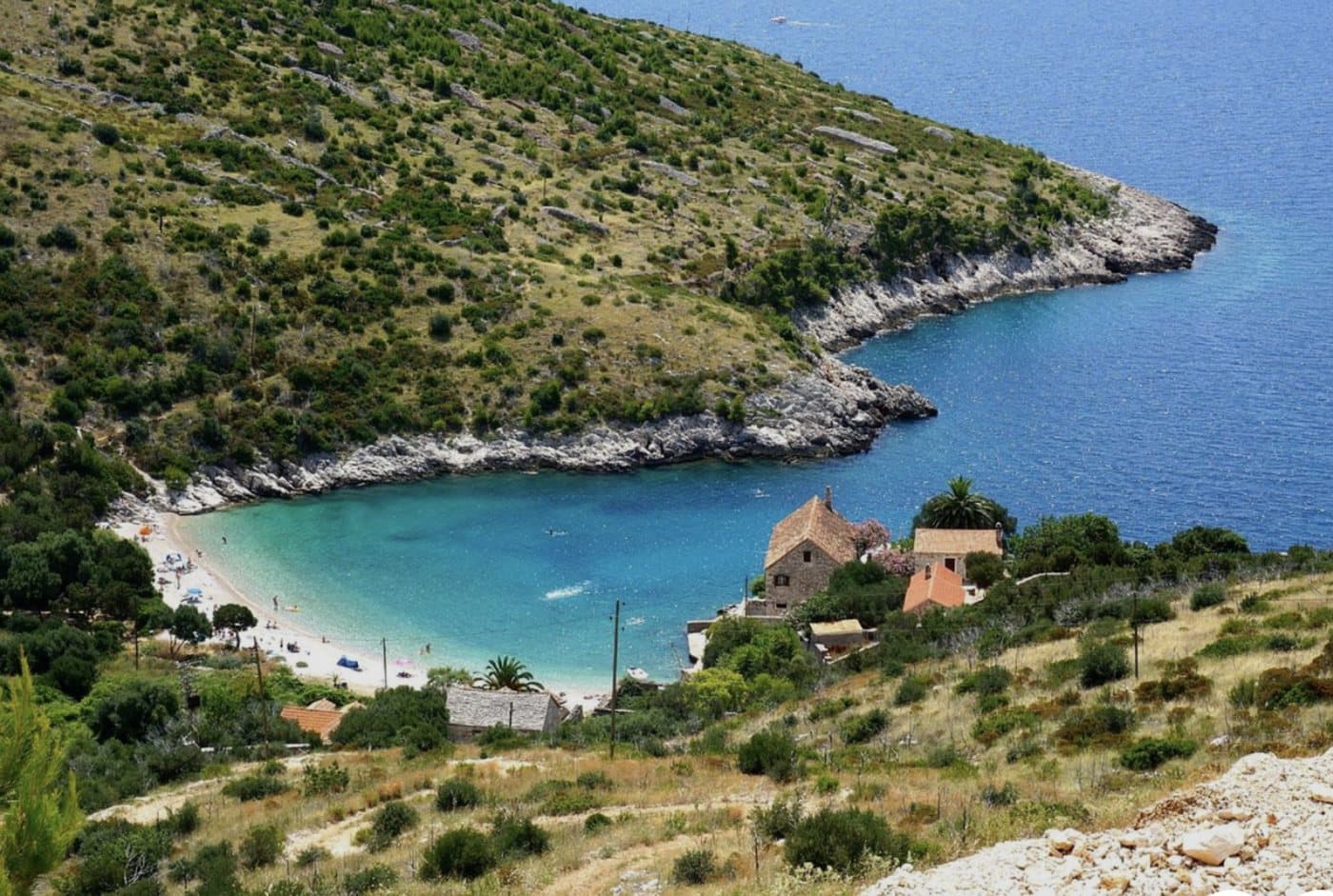 Dubovica Bay from above — white pebble arc, stone houses and turquoise water
