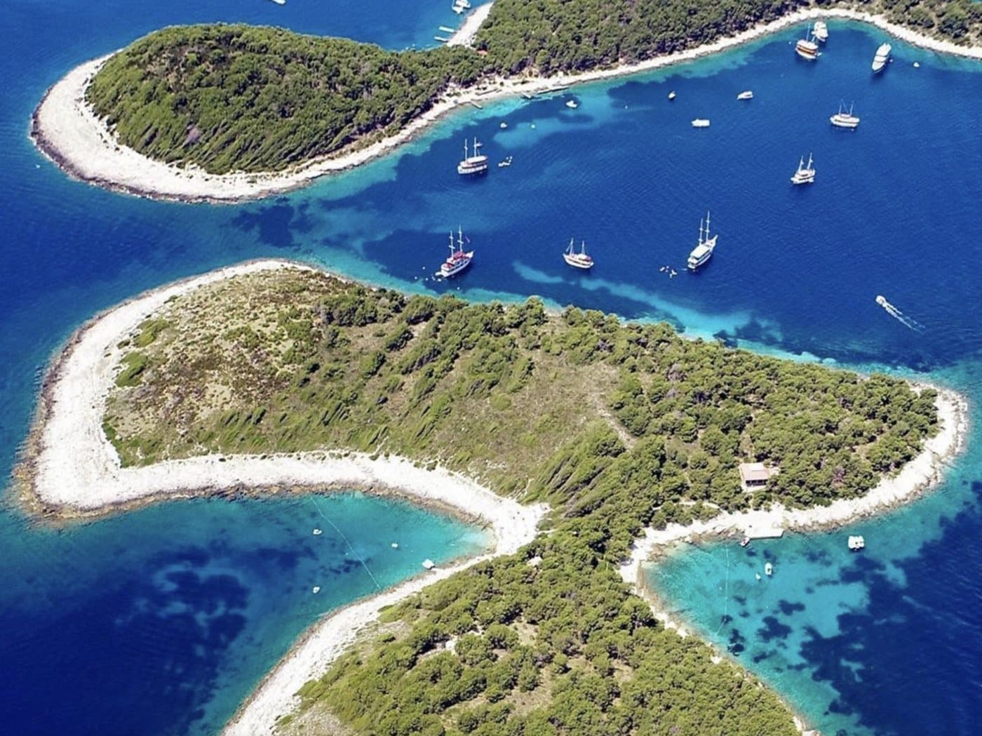 Jerolim and the Pakleni channel from the air — pine islets, white shores and boats at anchor