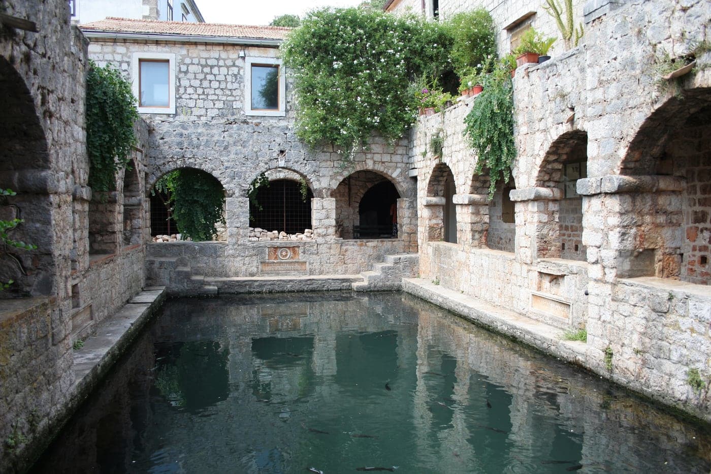 The fishpond in the courtyard of Tvrdalj, Stari Grad — stone arcades and still water