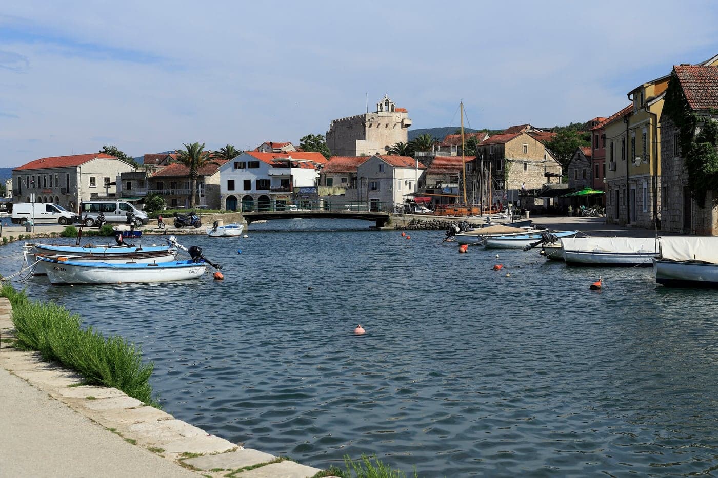 Vrboska from the first bridge — the canal, stone houses and the church-fortress beyond